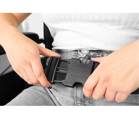 Person adjusting a black belt buckle on gray pants.